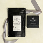 Seahorse Hot Cocoa Mix and a chocolate sampler box on beige background