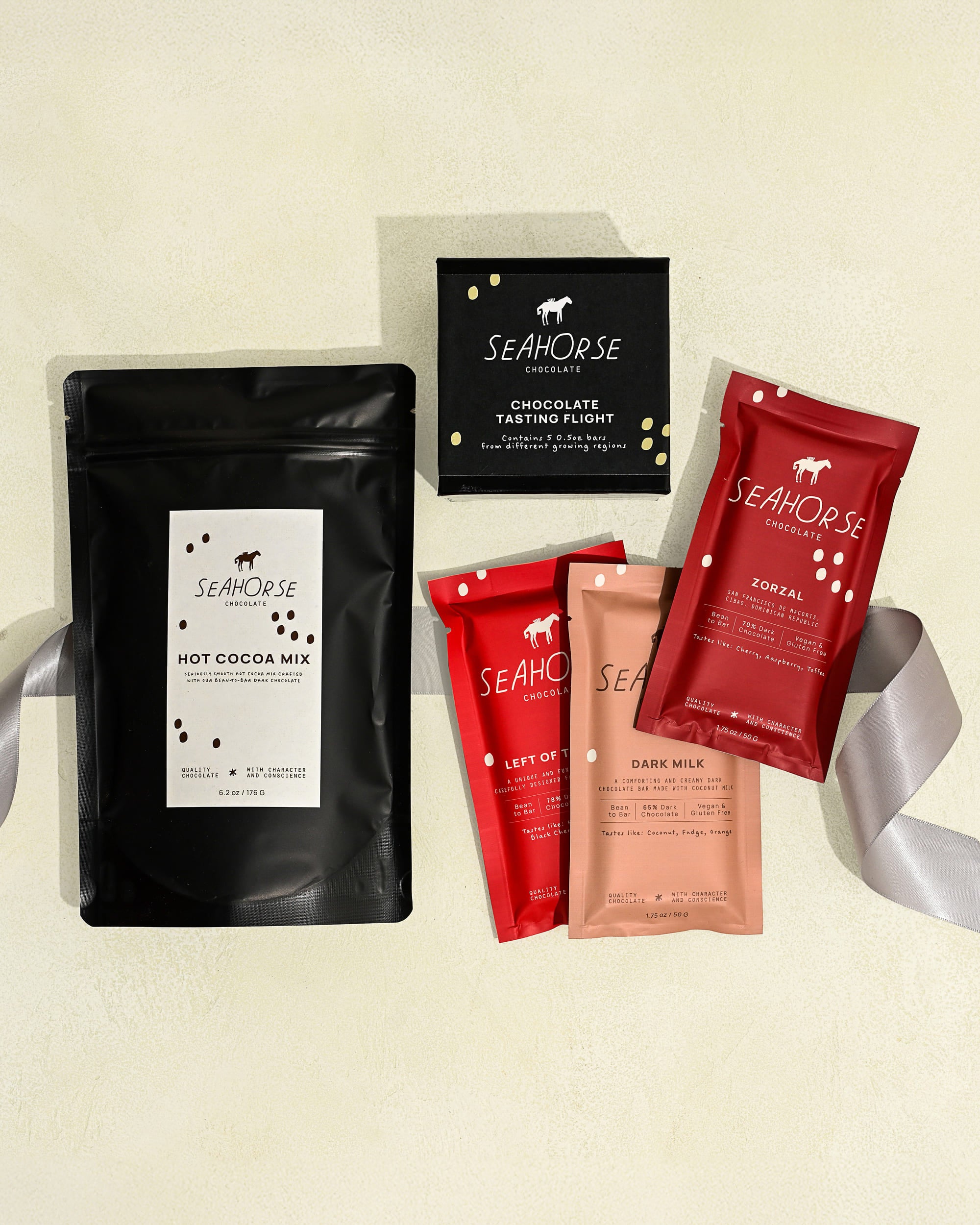 Collection of Seahorse hot chocolate mix, chocolate bars, and chocolate sampler on a light beige background