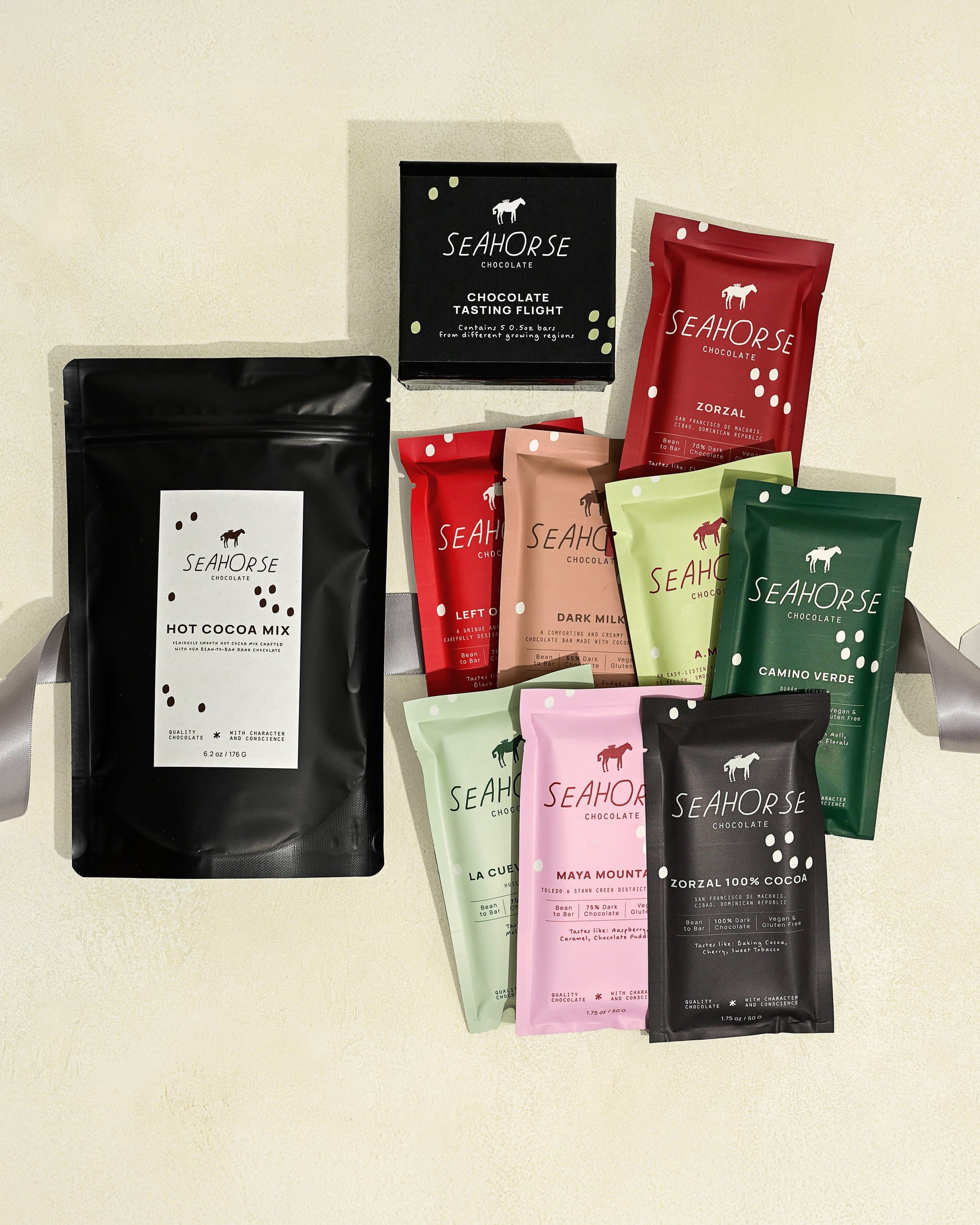 Collection of Seahorse chocolate products including hot cocoa mix and various chocolate bars and chocolate sampler on a light background.