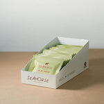 Box of Seahorse tea bags on a wooden surface with a light gray background