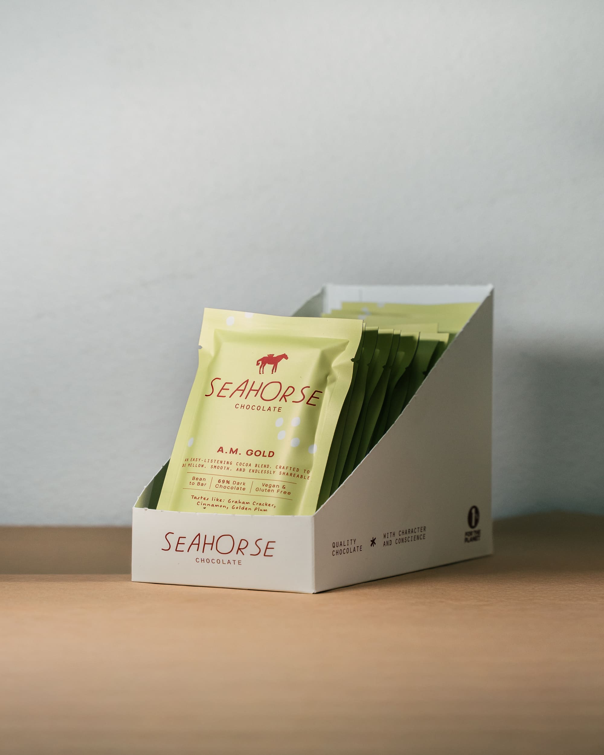 Box of Seahorse chocolate with a single package on a neutral background